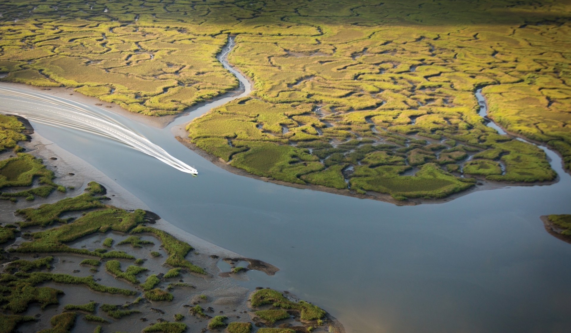 An aerial view of a boat traversing a river