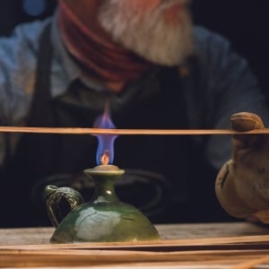 A bamboo fly rod being straightened over a flame