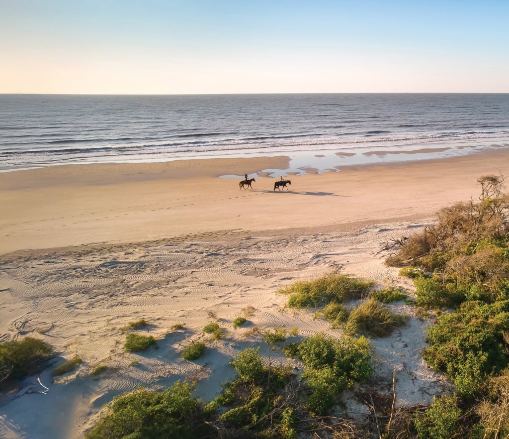 Two riders on horseback on the beach