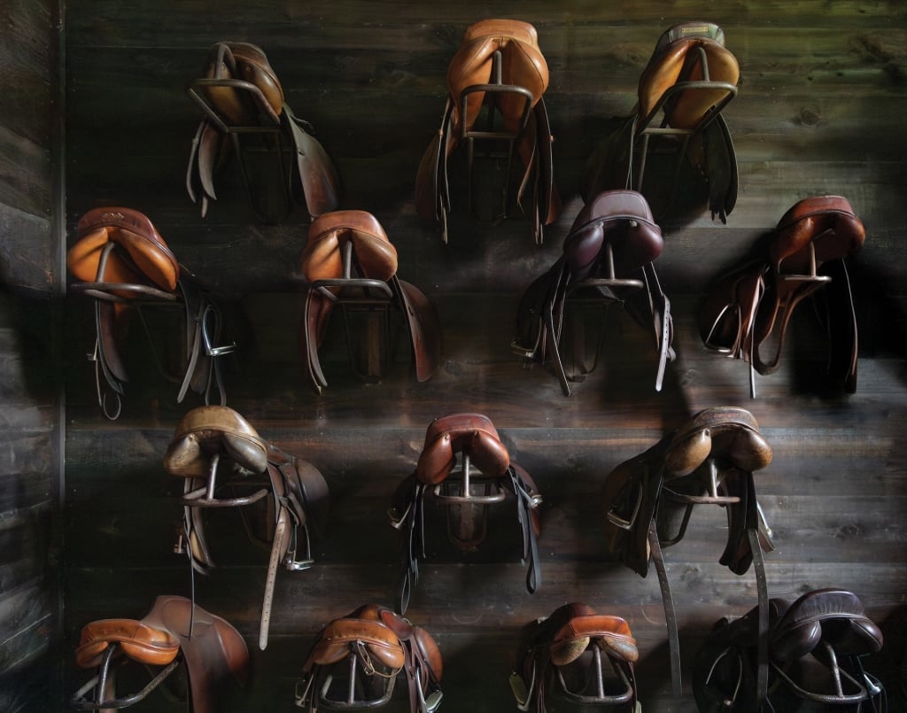 A wall of leather horse saddles