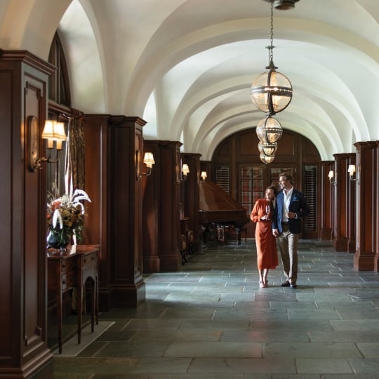 A couple walks down a grand hallway