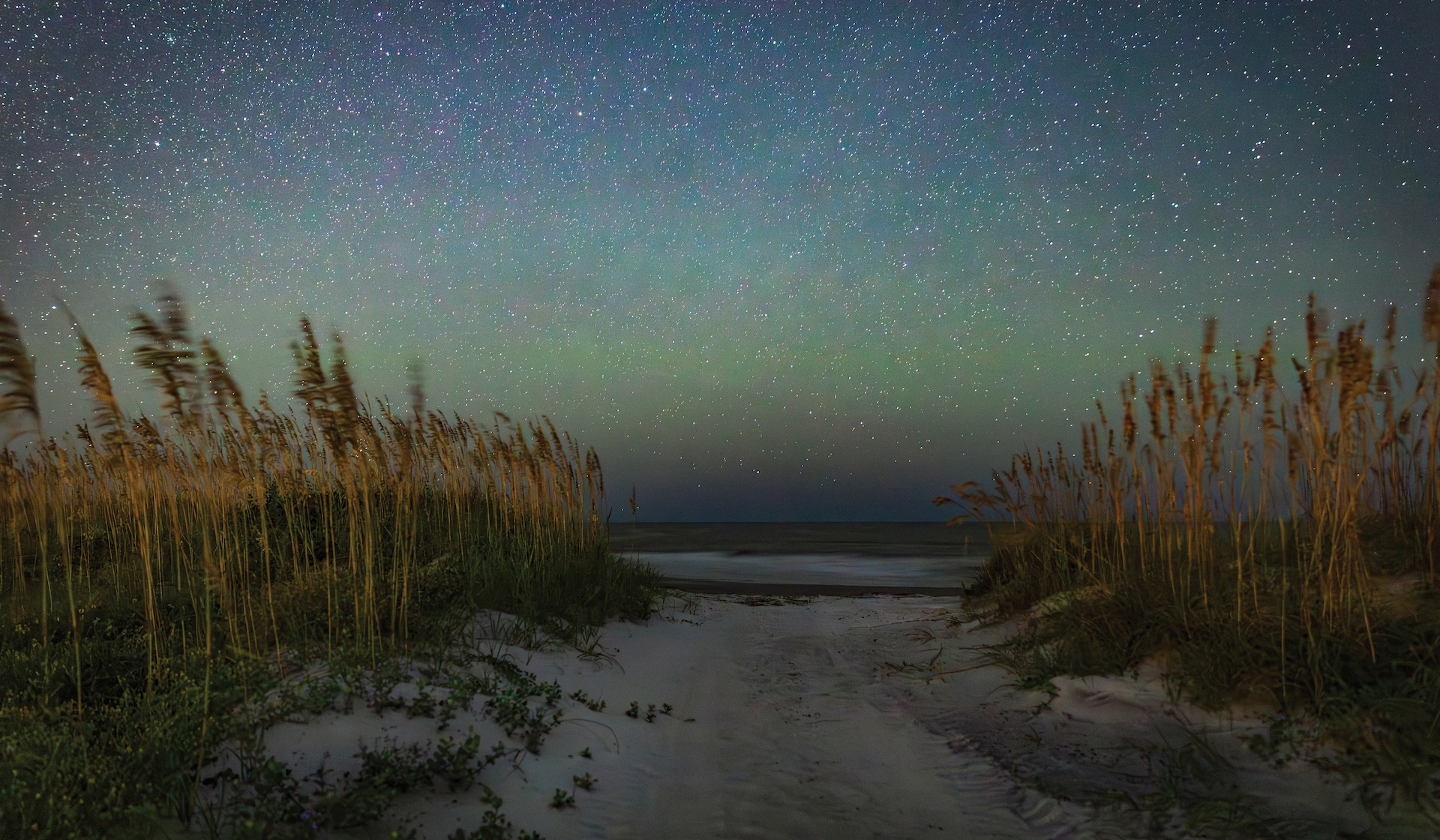 A green blue sky above a beach at dusk