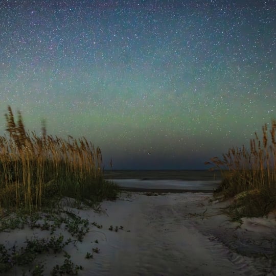 A green blue sky above a beach at dusk