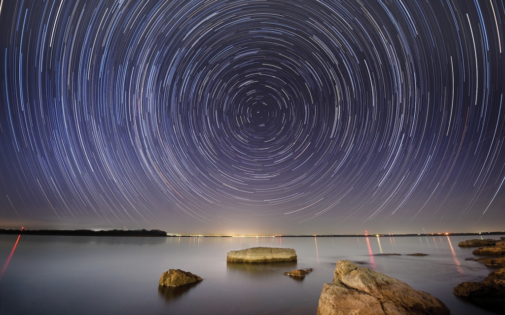 An hour-long “star-trail” displays the apparent motion of stars in the night sky due to the Earth’s rotation.